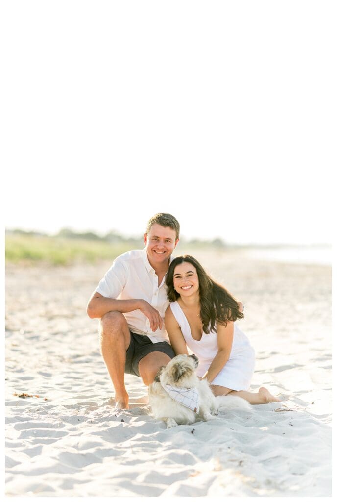 Cuddling with their dog on the beach during Gloucester engagement photos