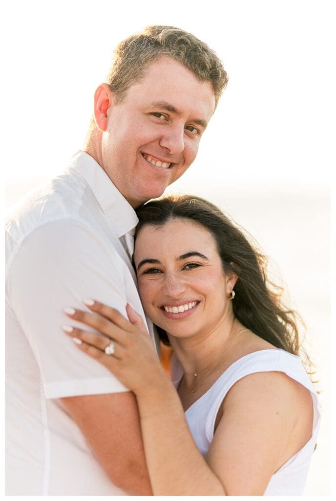 Close-up of an embrace and laughter during beach engagement photos