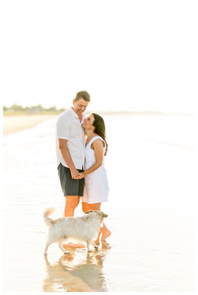Standing together on the beach with their dog