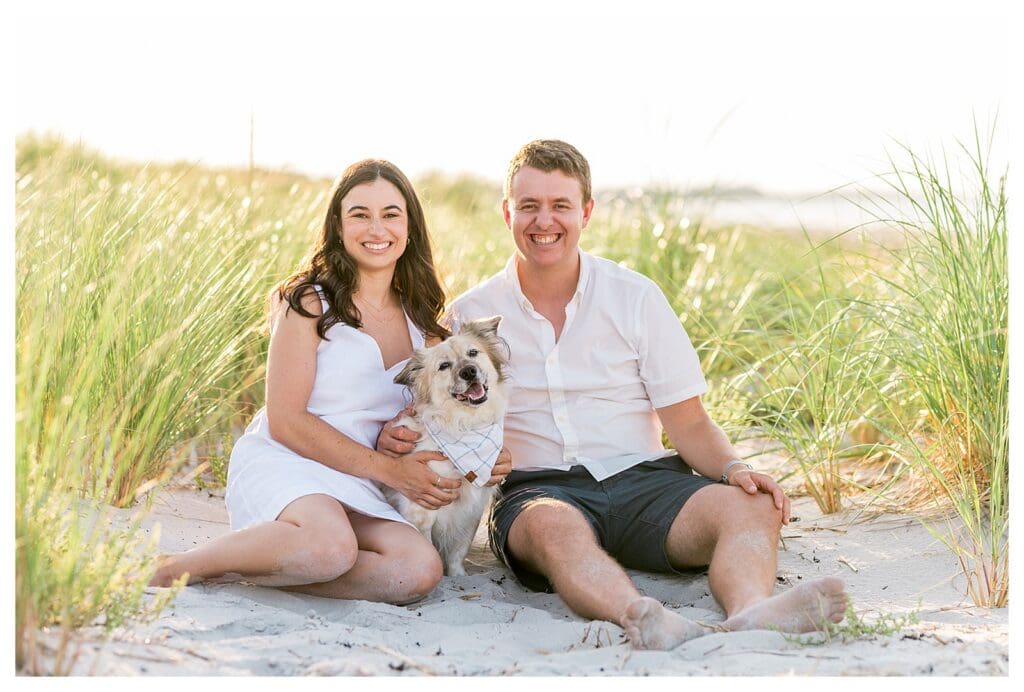 Sitting together in the beach grass with their dog