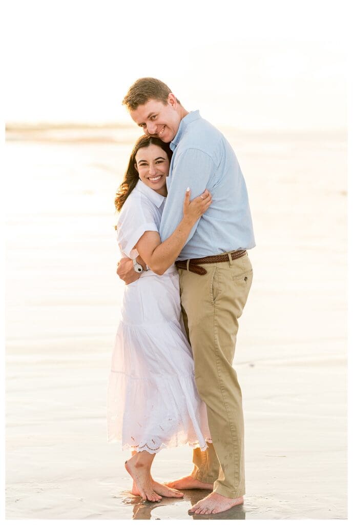 Romantic embrace during beach engagement photos