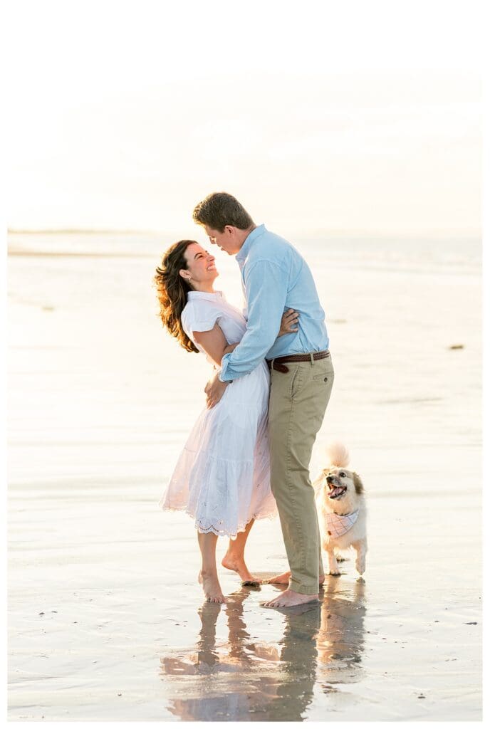 Embracing on the beach with soft sunset light behind them