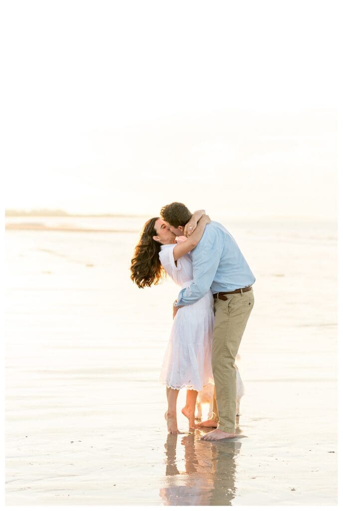 Kissing while embracing on the beach at golden hour